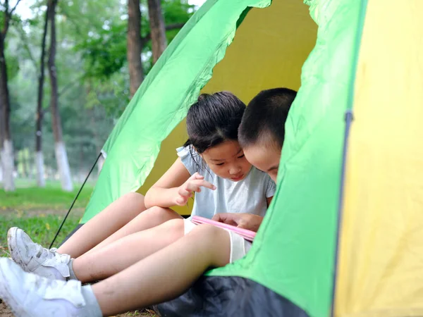 Duas crianças brincando com tablets na tenda — Fotografia de Stock