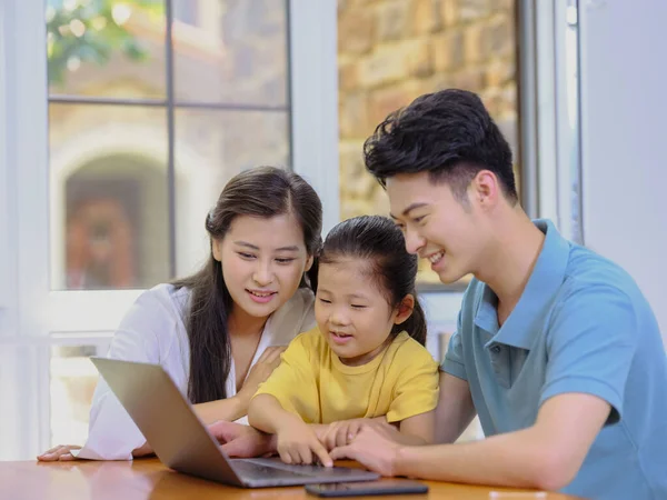 Uma família feliz de três usando laptop — Fotografia de Stock