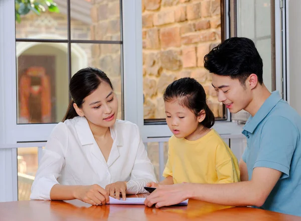 En lycklig familj på tre med miniräknare — Stockfoto