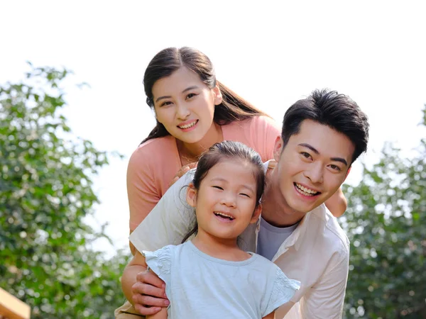 Familia feliz de tres en la foto de grupo al aire libre —  Fotos de Stock