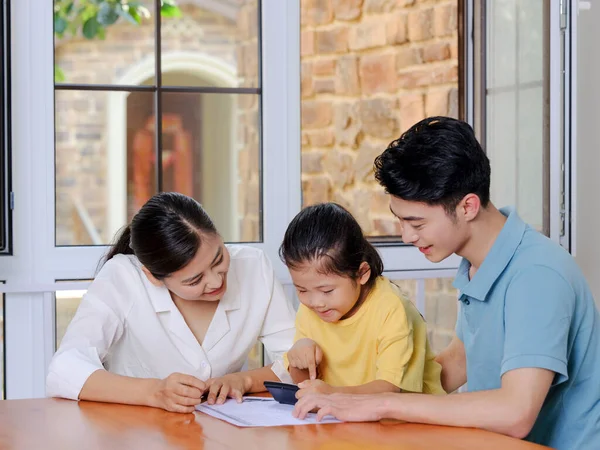 Uma família feliz de três usando calculadora — Fotografia de Stock