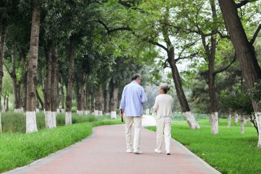 Parkta yürüyen mutlu yaşlı çift