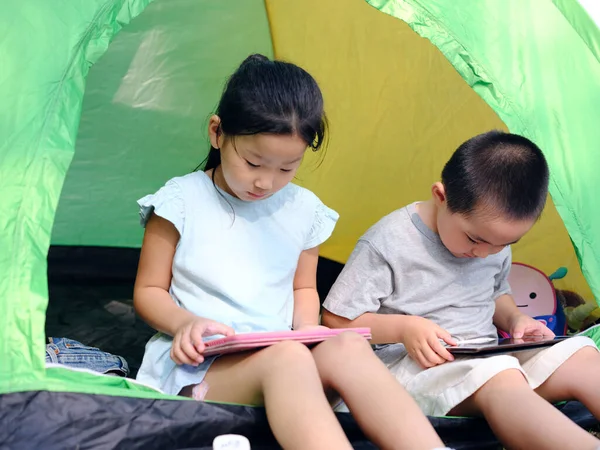 Duas crianças brincando com tablets na tenda — Fotografia de Stock