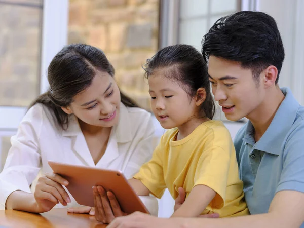 Uma família feliz de três usando tablet — Fotografia de Stock