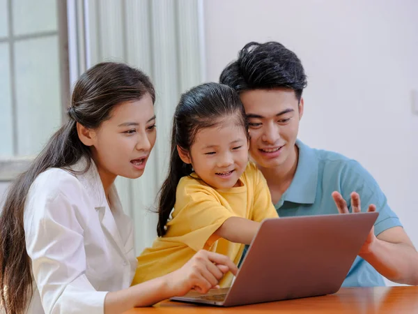Una familia feliz de tres usando el ordenador portátil — Foto de Stock