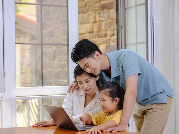 En lycklig familj på tre med bärbar dator — Stockfoto