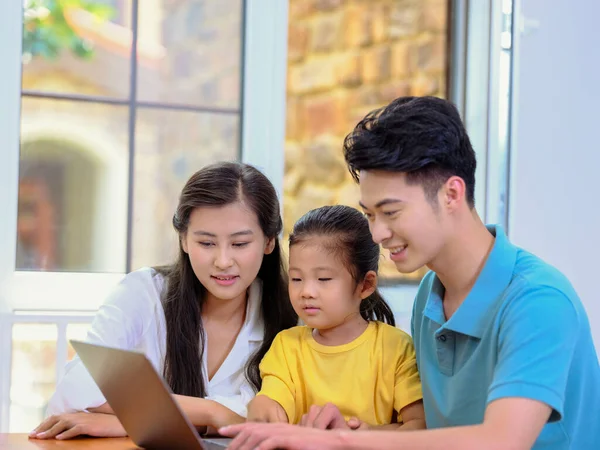 Eine glückliche dreiköpfige Familie mit Laptop — Stockfoto