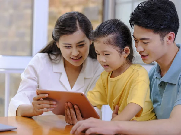 Uma família feliz de três usando tablet — Fotografia de Stock