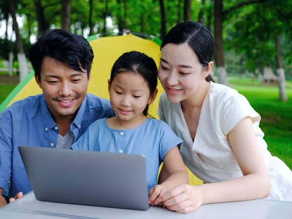 インターネットを屋外でサーフィンするために3つの使用コンピュータの幸せな家族 — ストック写真
