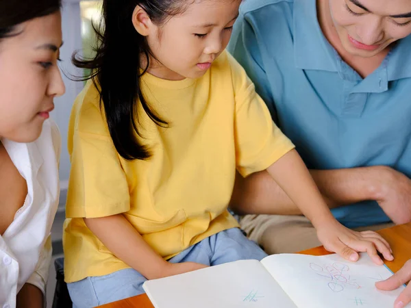 Junge Eltern helfen ihren Kindern bei den Hausaufgaben — Stockfoto