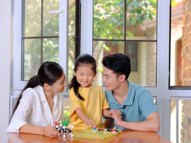 Üç kişilik mutlu bir aile moleküler yapı modelini birlikte yapıyor.