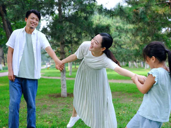 Šťastná trojčlenná rodina hrající si v parku — Stock fotografie