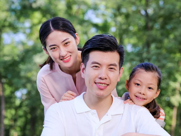 Happy family of three playing in the park