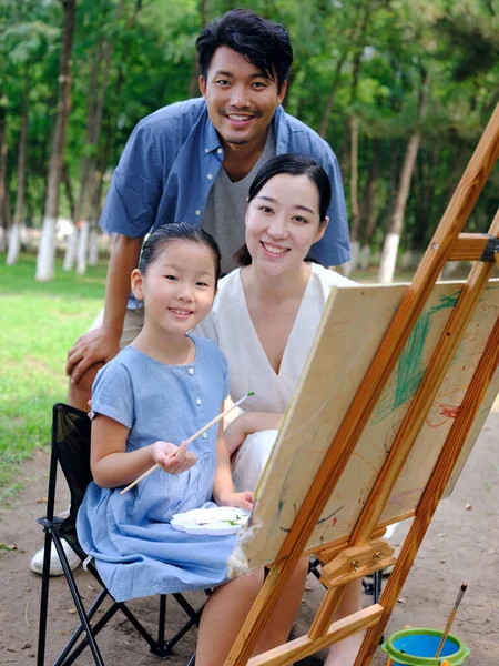 Uma família feliz de três pintura ao ar livre — Fotografia de Stock