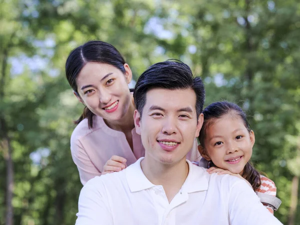 Glückliche dreiköpfige Familie spielt im Park — Stockfoto