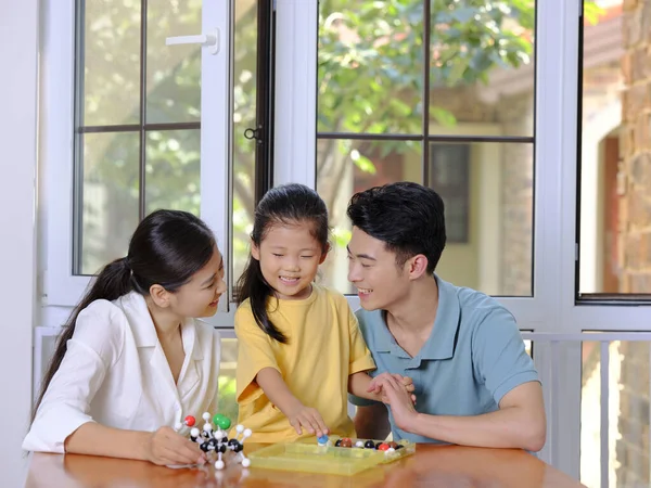 Família feliz de três fazendo modelo de estrutura molecular juntos — Fotografia de Stock