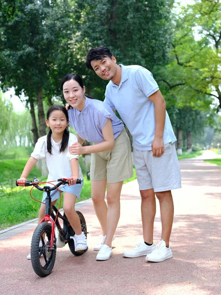Родители учат своих детей кататься на велосипедах — стоковое фото