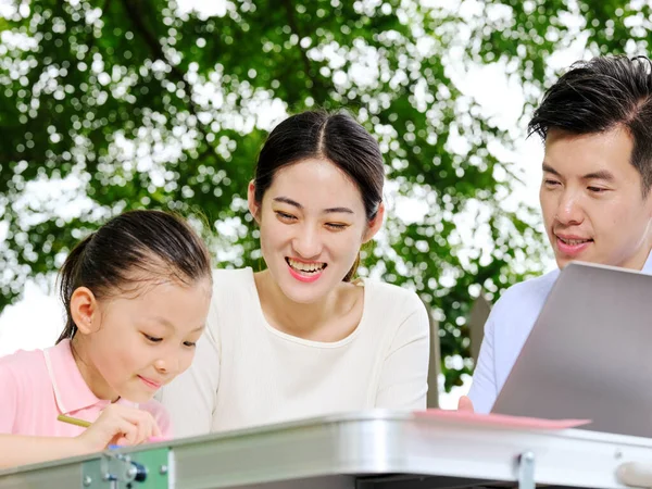 Genç ebeveynler çocuklarına dışarıda ödevlerinde yardım ederler.