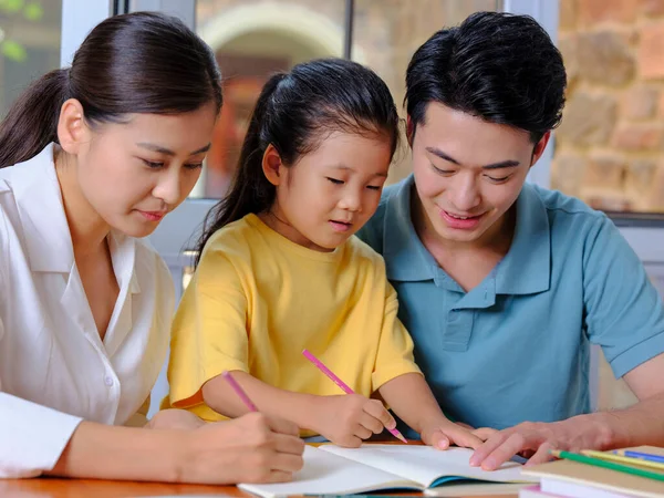 Jonge ouders helpen hun kinderen met hun huiswerk — Stockfoto