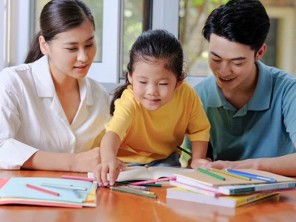 Junge Eltern helfen ihren Kindern bei den Hausaufgaben — Stockfoto