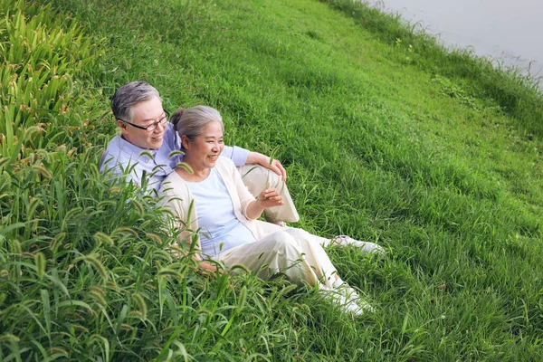 Casal velho feliz assistindo a paisagem junto ao lago — Fotografia de Stock