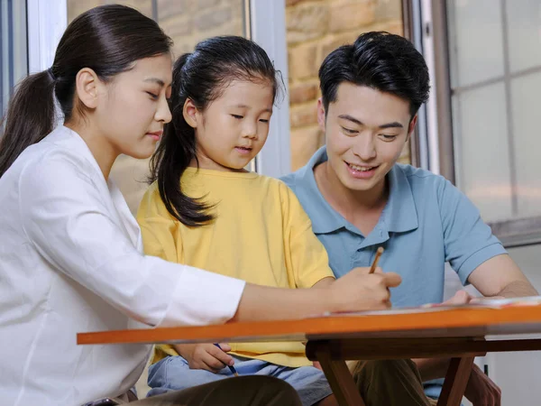 Young parents help their children with their homework