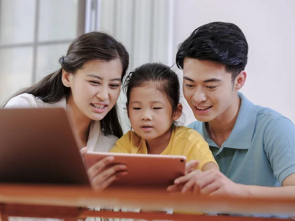 Eine glückliche dreiköpfige Familie mit Tablet — Stockfoto