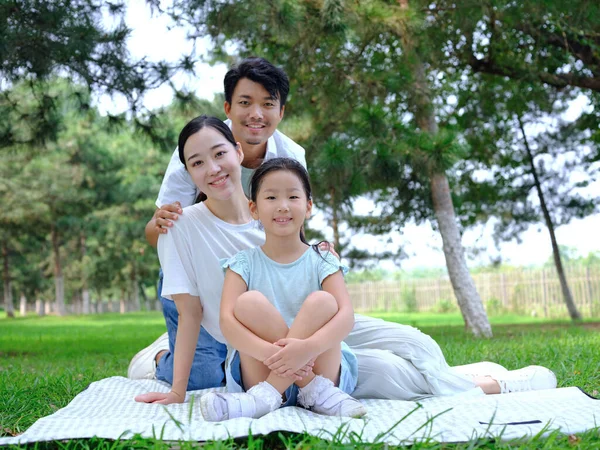 Šťastná trojčlenná rodina hrající si v parku — Stock fotografie