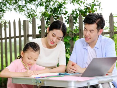 Genç ebeveynler çocuklarına dışarıda ödevlerinde yardım ederler.