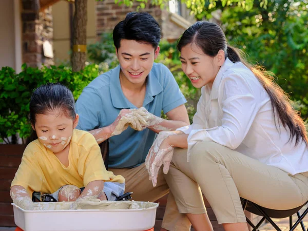 Happy family of three doing pottery together outdoors — Stock Photo, Image