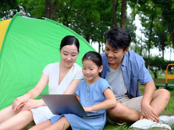 快乐的三口之家在户外用电脑上网 — 图库照片