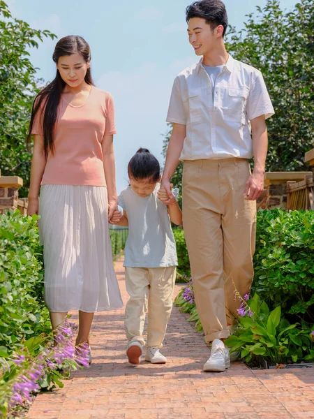 Uma família feliz de três caminhando ao ar livre — Fotografia de Stock