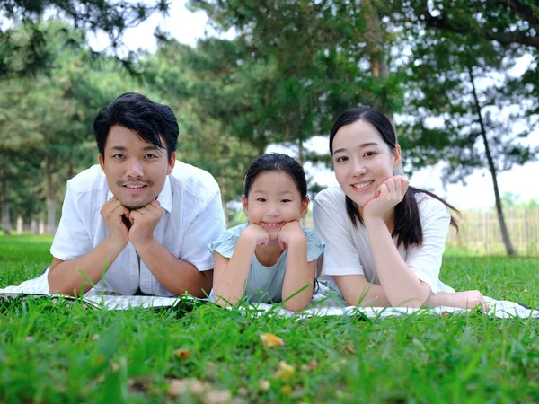 Щаслива сім'я з трьох грає в парку — стокове фото