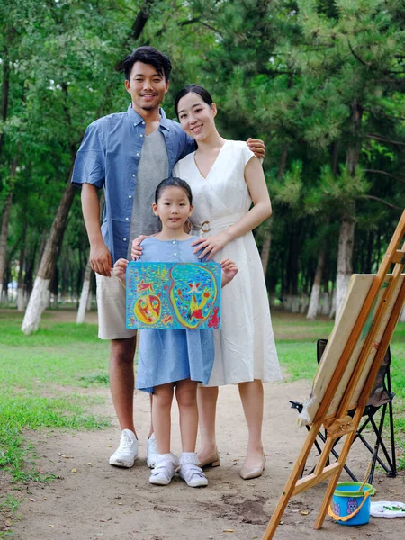 Uma família feliz de três pintura ao ar livre — Fotografia de Stock