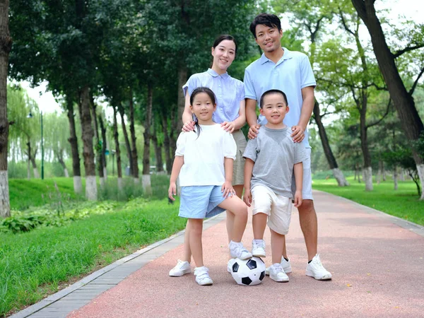 Famiglia felice di quattro giocare a calcio nel parco — Foto Stock