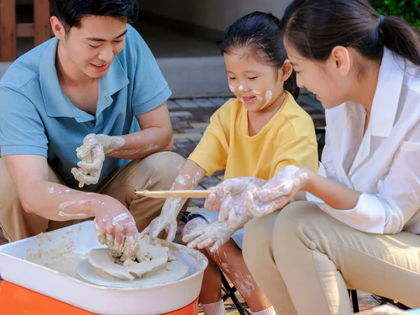 Happy family of three doing pottery together outdoors — Stock Photo, Image