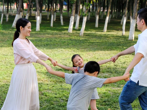 Lycklig familj på fyra som leker i parken — Stockfoto