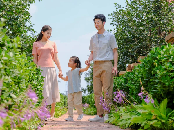 Uma família feliz de três caminhando ao ar livre — Fotografia de Stock