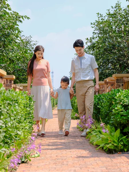 Uma família feliz de três caminhando ao ar livre — Fotografia de Stock