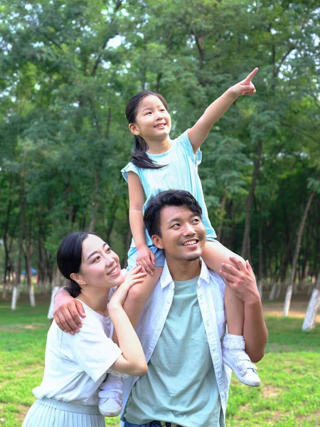 Счастливая семья из трех человек играет в парке — стоковое фото