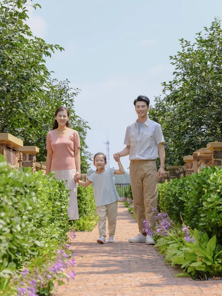 Uma família feliz de três caminhando ao ar livre — Fotografia de Stock