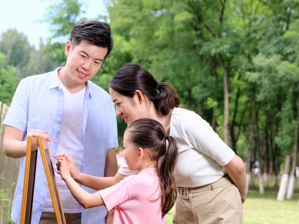 Boldog család három festményből a parkban — Stock Fotó