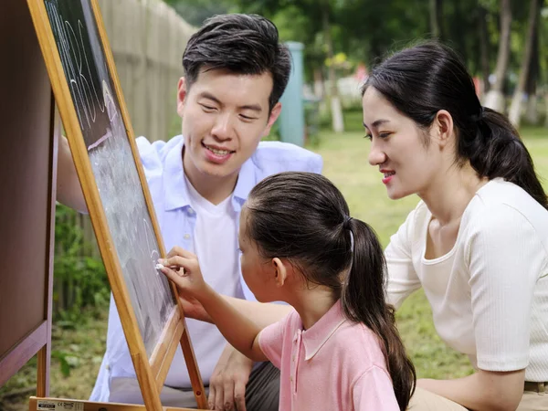 Lycklig familj med tre målningar i parken — Stockfoto