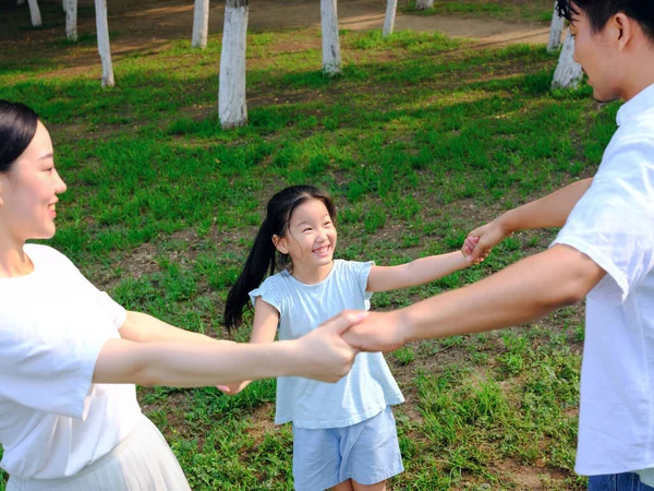 Famiglia felice di tre persone che giocano nel parco — Foto Stock