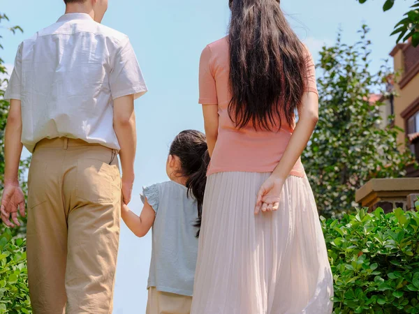 Uma família feliz de três caminhando ao ar livre — Fotografia de Stock