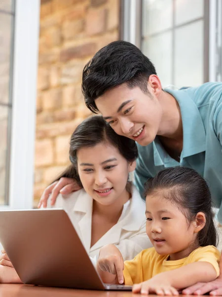 Eine glückliche dreiköpfige Familie mit Laptop — Stockfoto