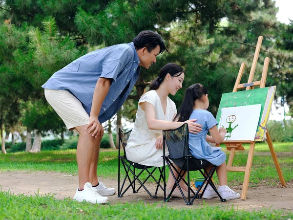 Uma família feliz de três pintura ao ar livre — Fotografia de Stock