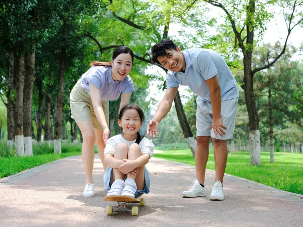Una familia feliz de tres patinetas —  Fotos de Stock