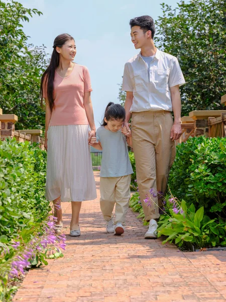 Uma família feliz de três caminhando ao ar livre — Fotografia de Stock