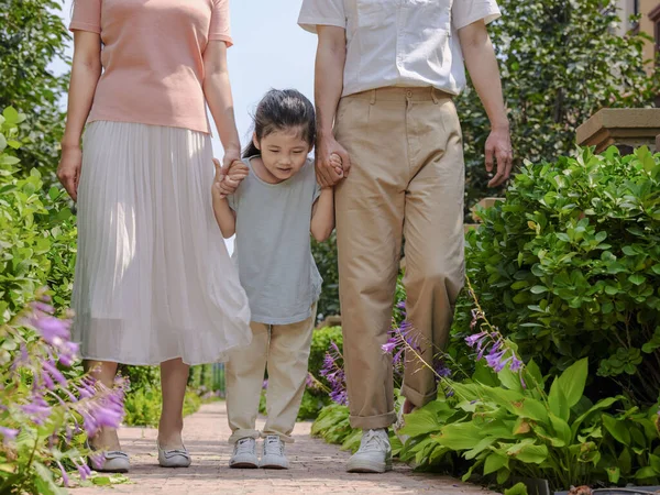 Uma família feliz de três caminhando ao ar livre — Fotografia de Stock